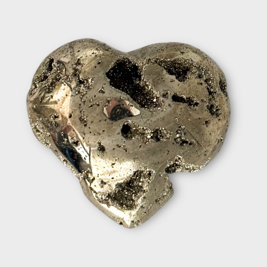 Which Crystal is Right for Me? Pyrite Heart on a gray background.