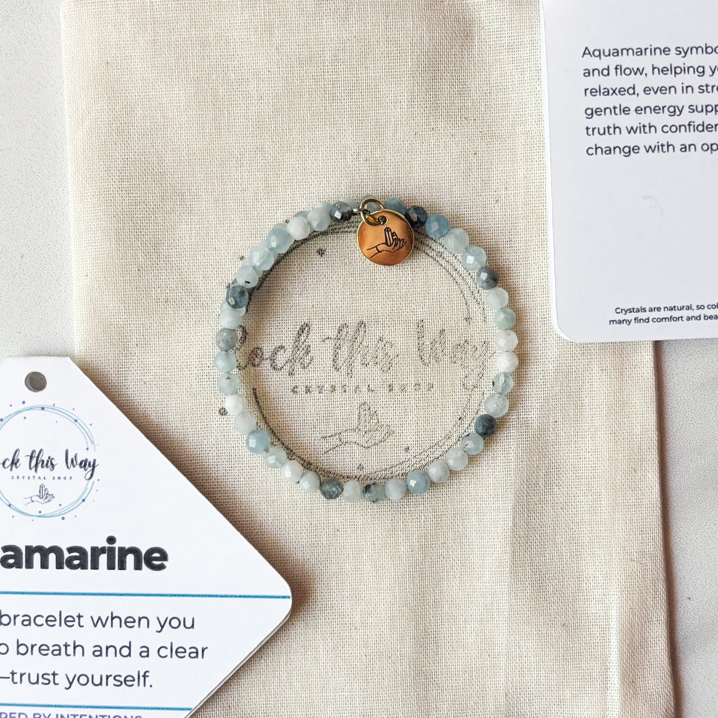 Blue aquamarine wrap bracelet with a stainless steel band displayed with bracelet cards and pouch.