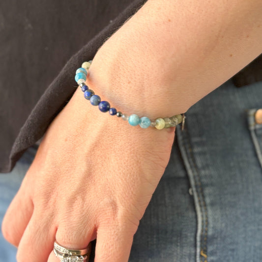 Balance Bangle on wrist with blue and green.