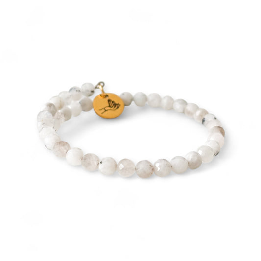Handcrafted Moonstone bracelet laid flat, highlighting flexible stainless steel wrap design.
