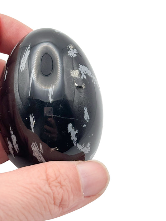 Side view of polished Snowflake Obsidian egg with grounding black and white crystal texture