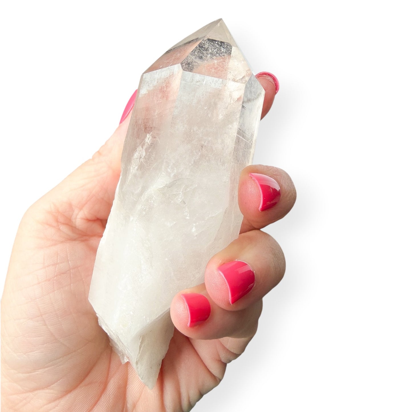 Hand holding a clear crystal with pink nail polish on a white background