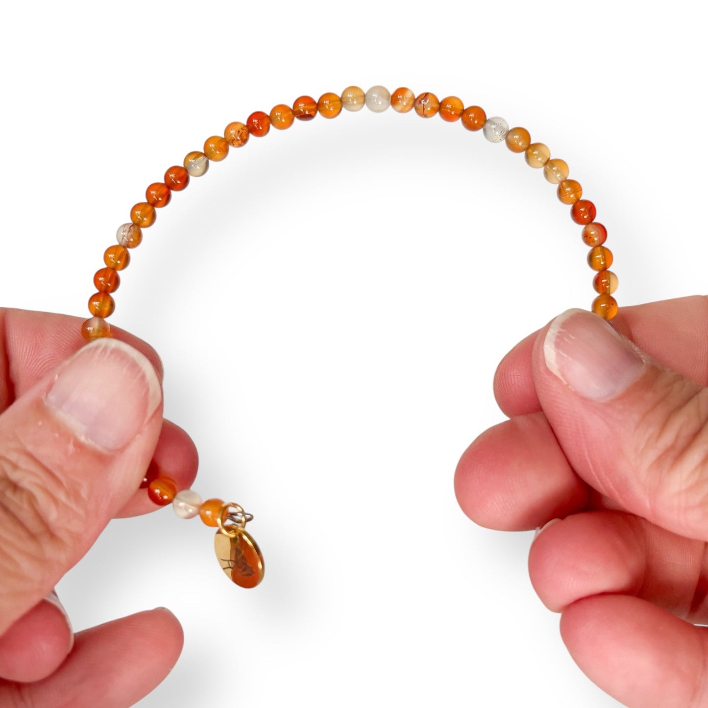Carnelian bracelet stretched to show the flexibility with the stainless steel band. Fits like and elastic but won't break like one.