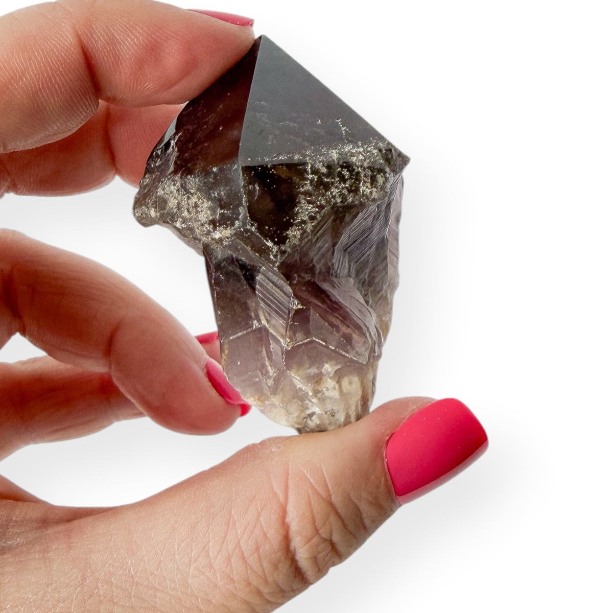 Side view of deep purple chevron amethyst in hand showing its natural details
