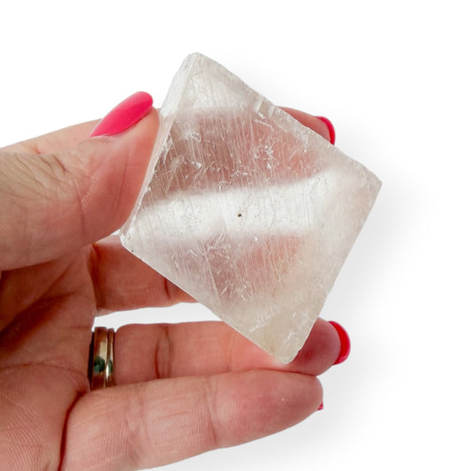 Icelandic spar in hand with slight translucency.