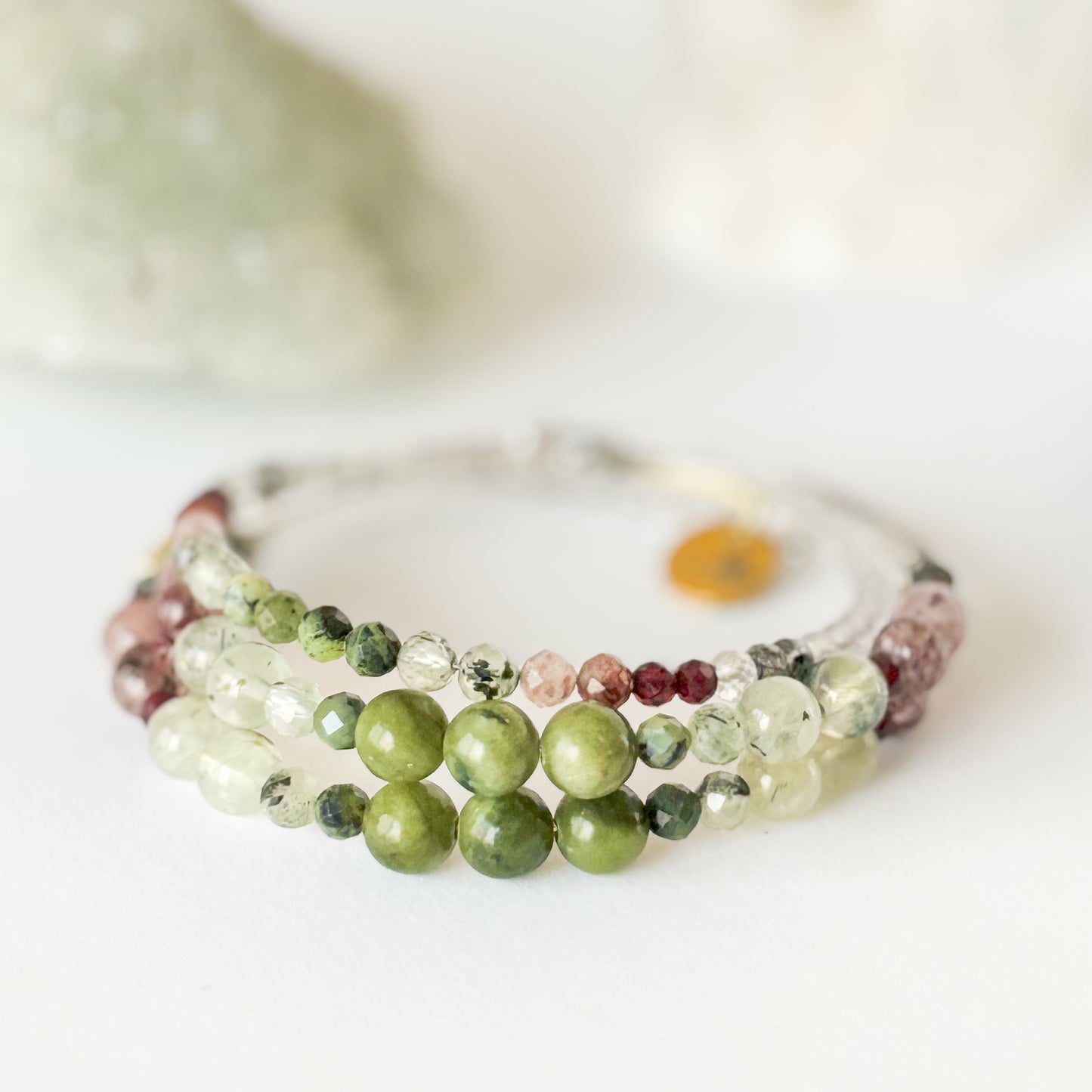Flatlay of Tenacious Wrap Bracelet showing blend of green, pink, and deep red crystal beads.