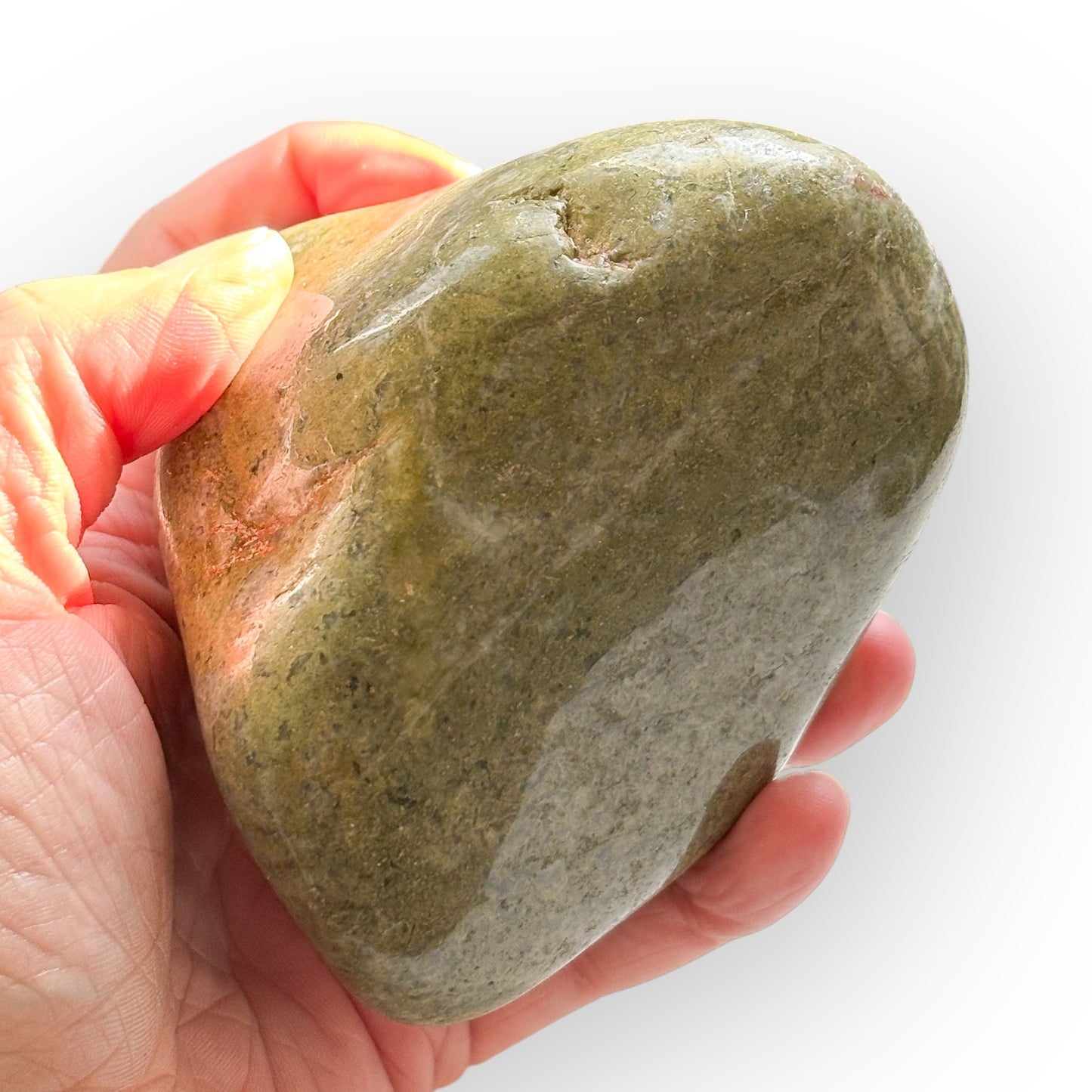 Hand holding large polished African Epidote to show scale