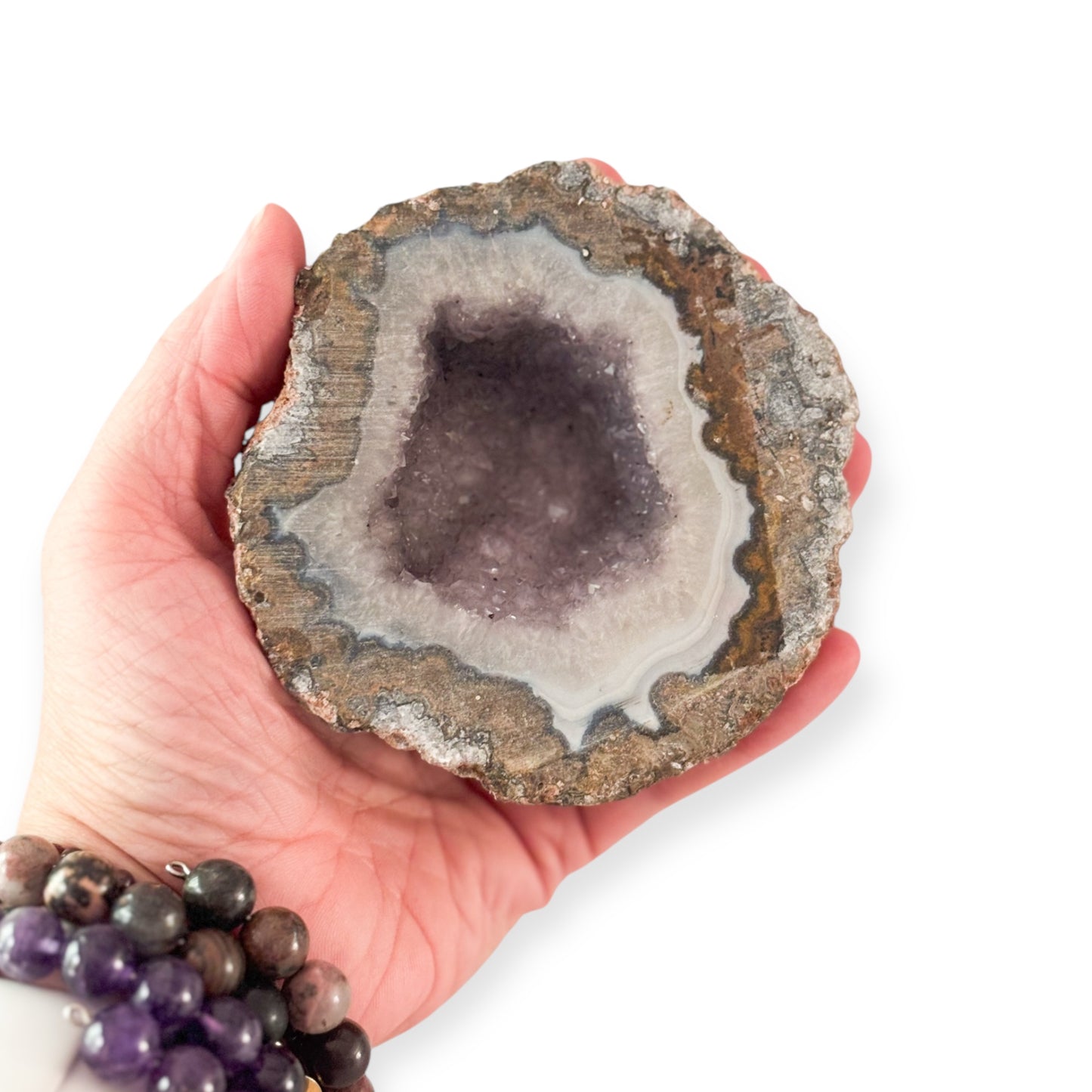 Hand holding Amethyst Quartz Geode for size reference