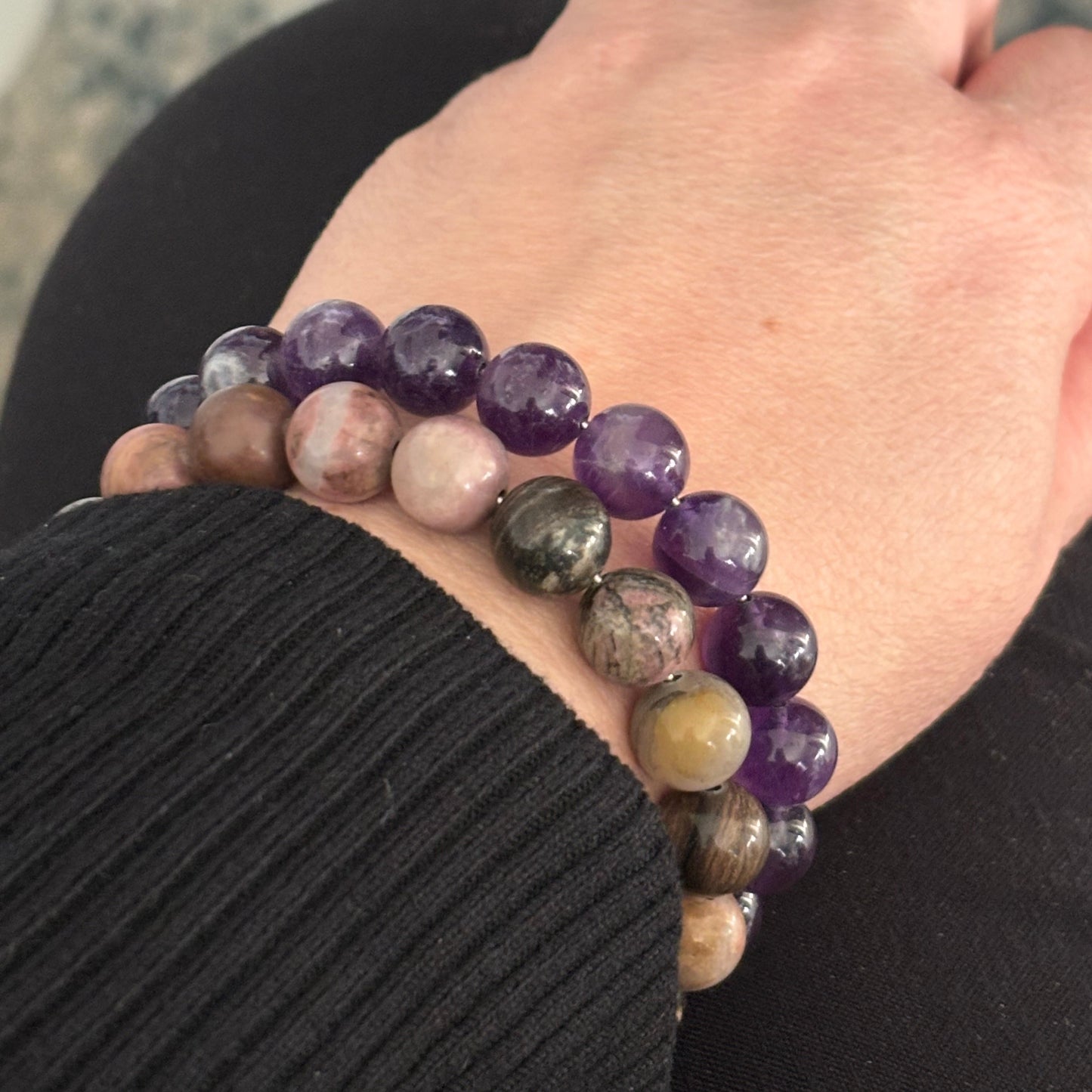 Amethyst crystal bracelet stacked with other gemstone bracelets for a layered look.