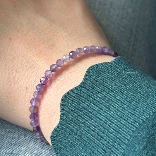 Amethyst wrap bracelet worn on wrist, highlighting its flexible wrap design and shimmering purple tone.