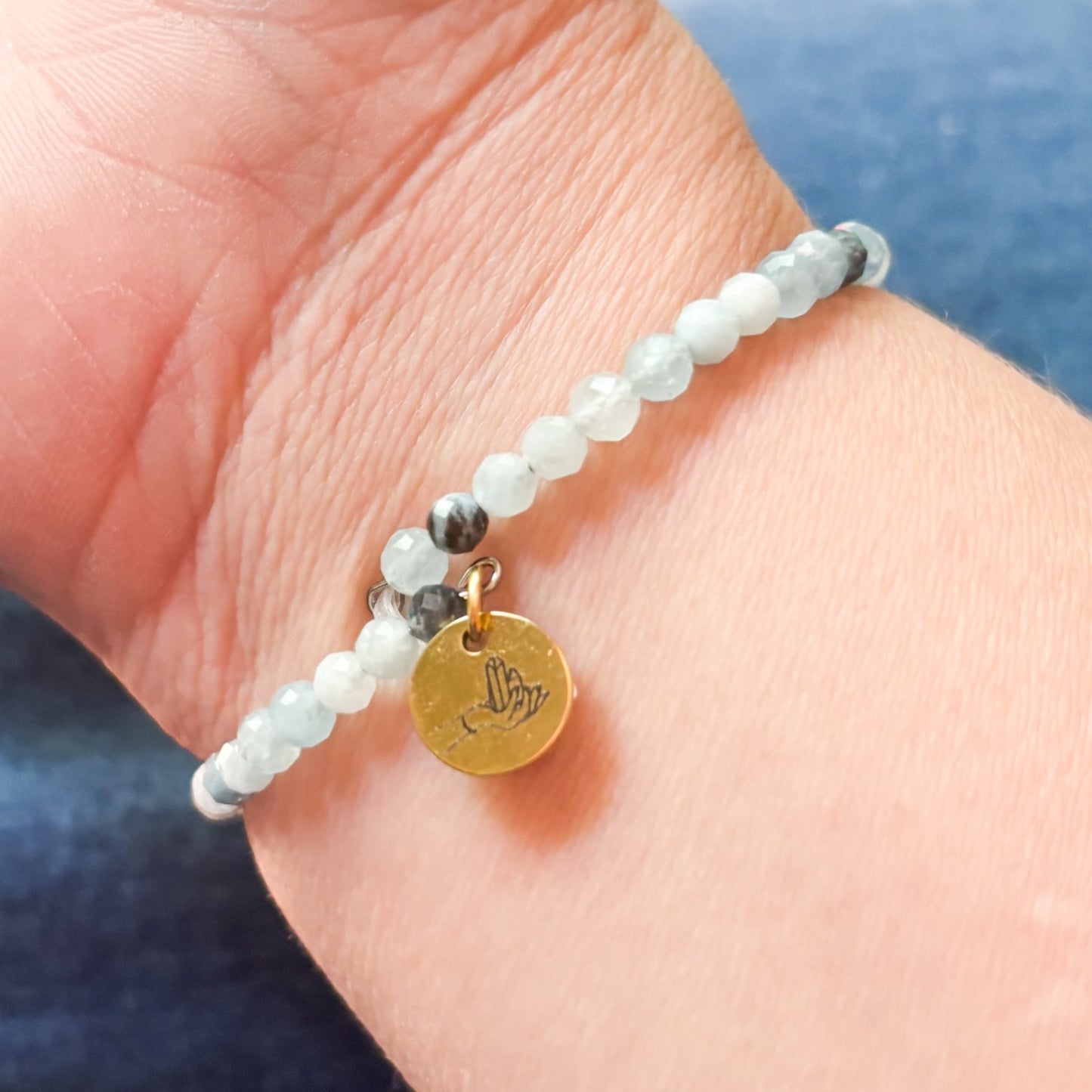 Model wearing the blue Aquamarine Wrap Bracelet showing the charm and closure.