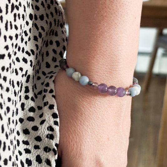 Aquarius Crystal Charm Bracelet with a black charm worn on wrist, emphasizing its adaptable and comfortable fit.