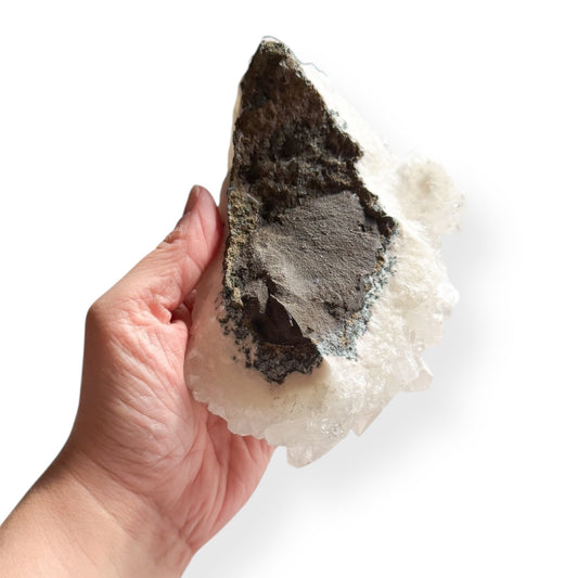 Back view of Arkansas Quartz Cluster with earthy base held in hand