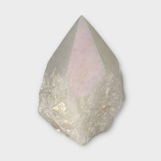 Polished Angel Aura Quartz point with raw base in soft natural light