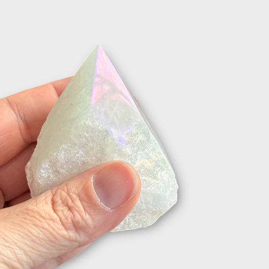 Aura Quartz point held in hand, showing shimmer and raw texture