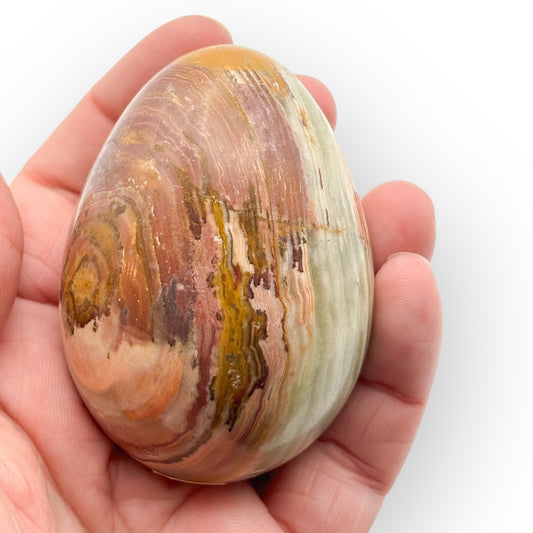 Large Banded Onyx egg from Pakistan held in hand showing layered earthy tones