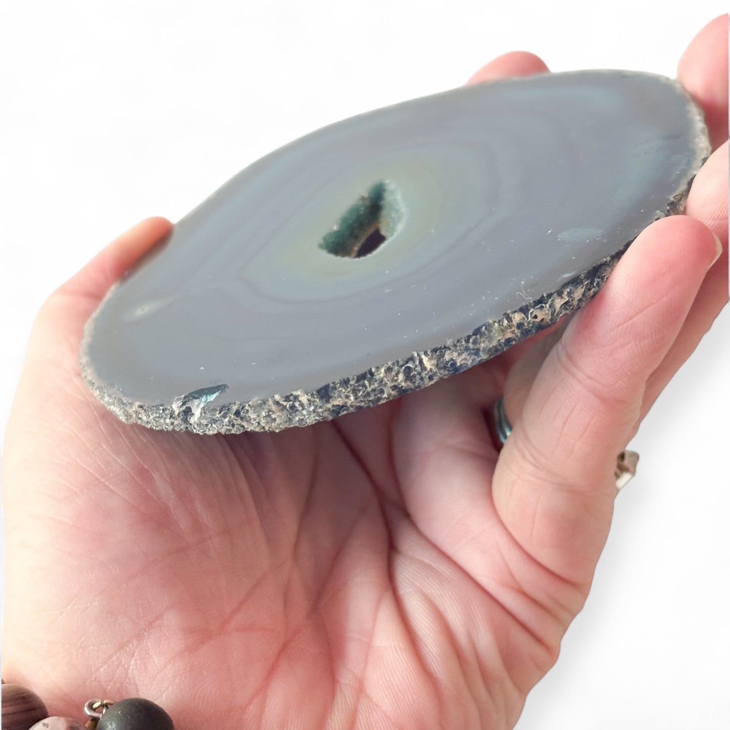 Angled view of blue agate slice with layered crystal bands and raw center