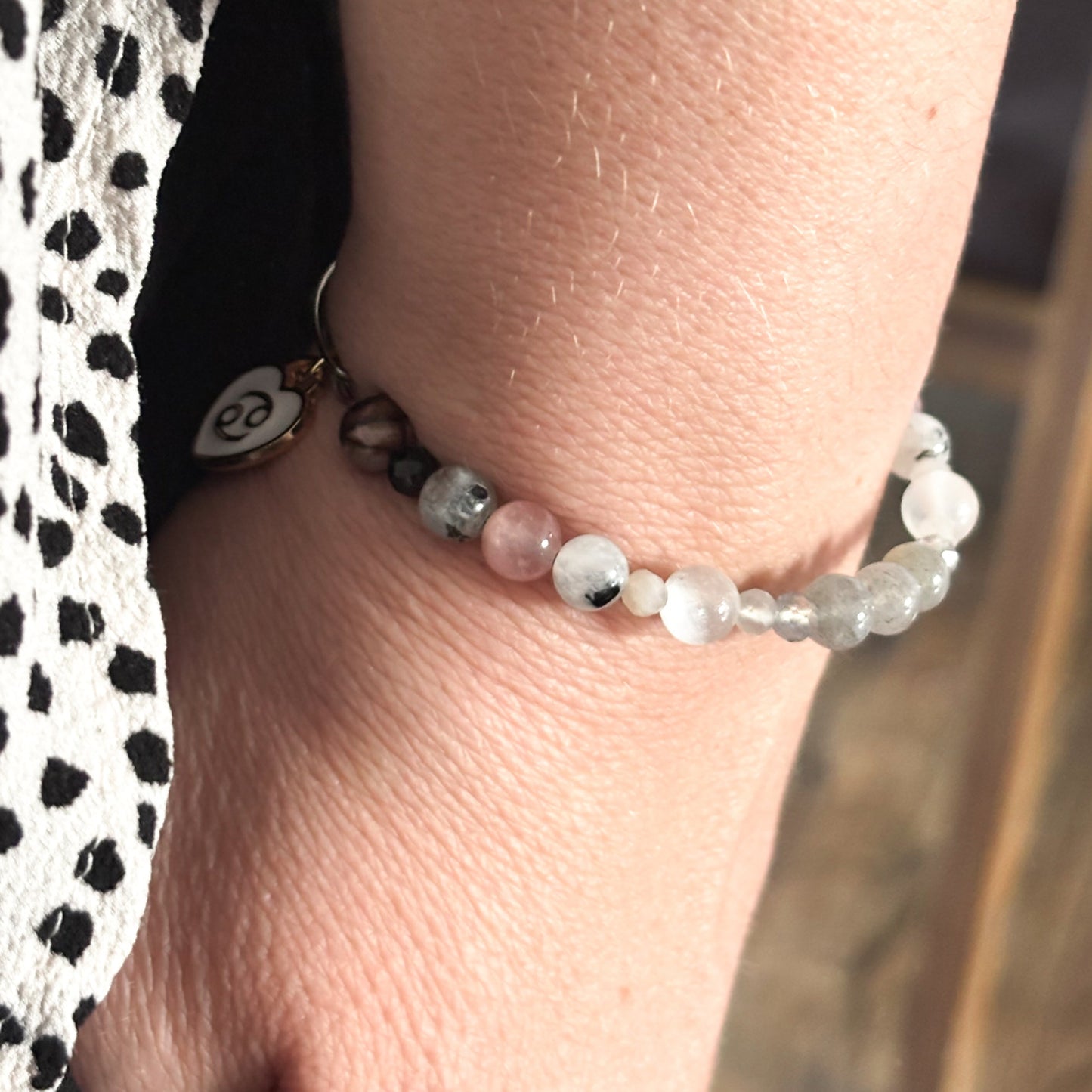 Cancer Crystal Charm Bracelet with a white charm worn on wrist, highlighting its comfortable, flexible fit.