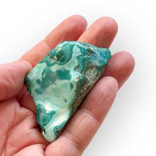 Polished Chrysocolla crystal held in hand showing size and shine
