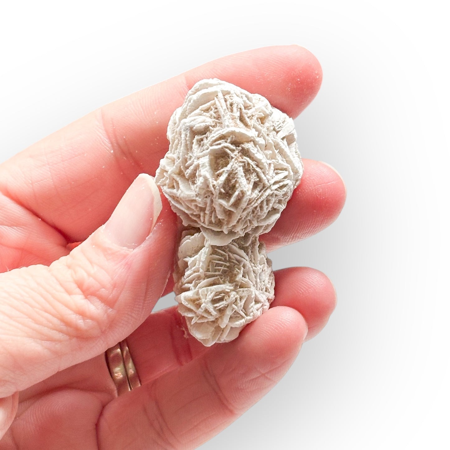 Hand holding Desert Rose Selenite crystal for scale reference