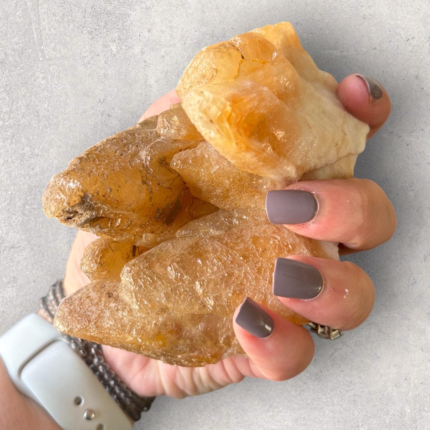 Dogtooth Calcite cluster held in hand for size and texture comparison