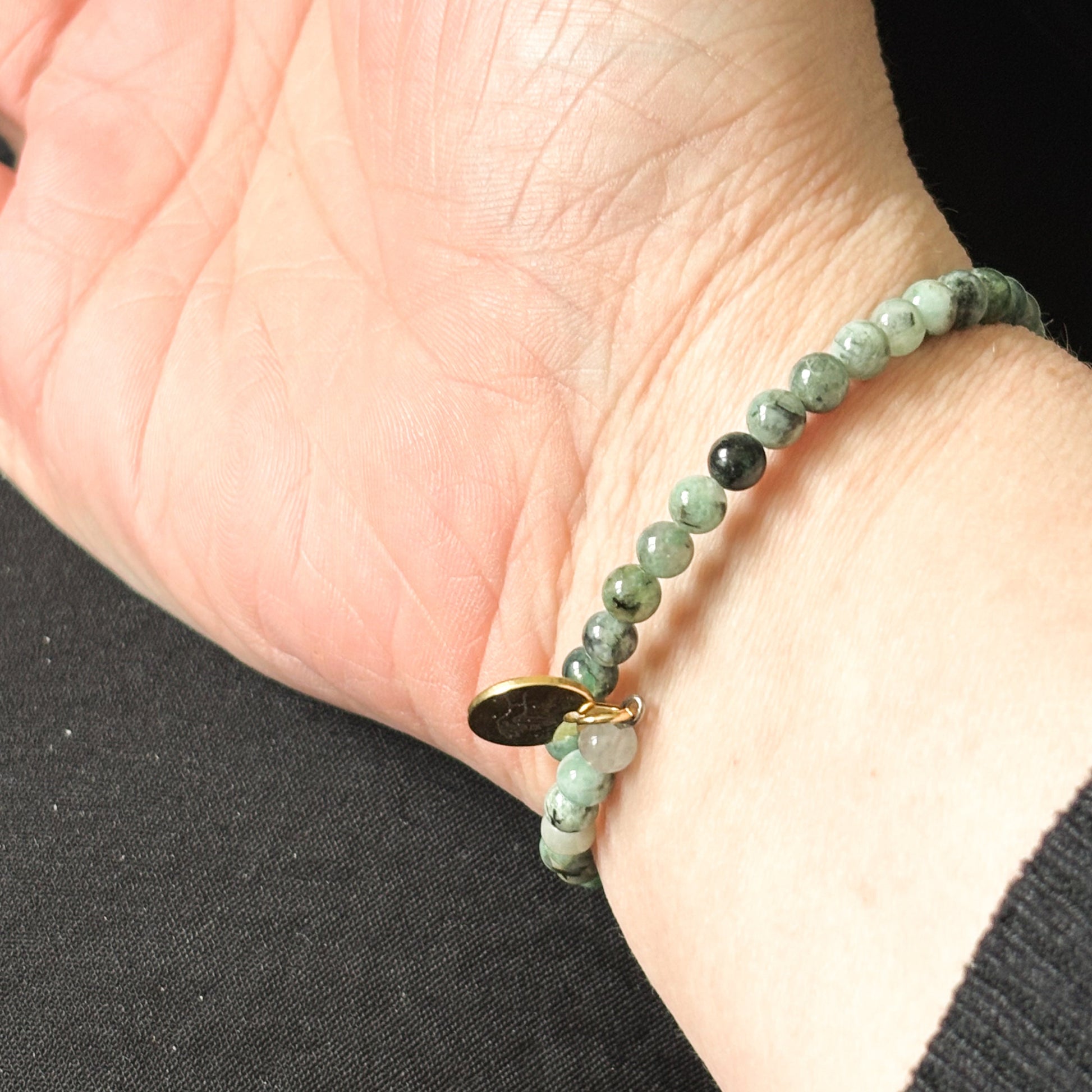 Close-up of Emerald wrap bracelet showcasing its vibrant green polished beads.