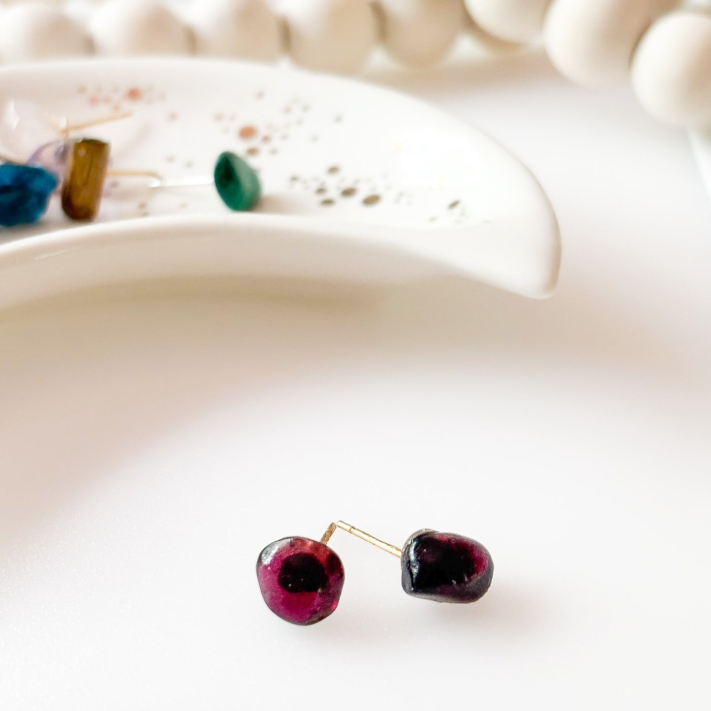Side angle of natural Garnet studs showing deep red color and texture