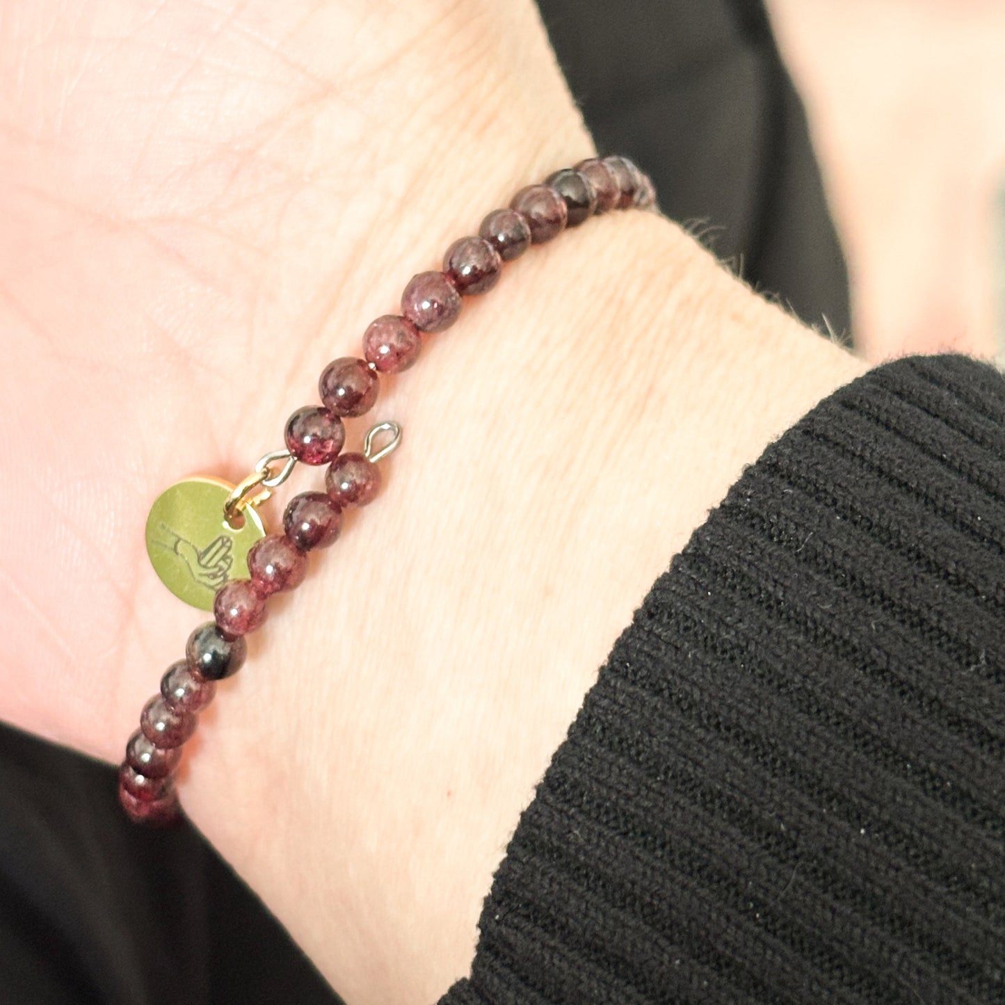 Garnet wrap bracelet in natural sunlight, revealing its rich red tones and elegant design.