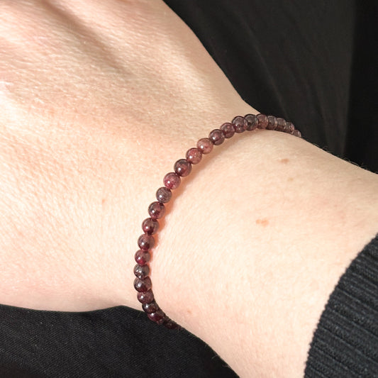 Garnet wrap bracelet worn on wrist, highlighting its smooth, polished finish and adjustable fit.