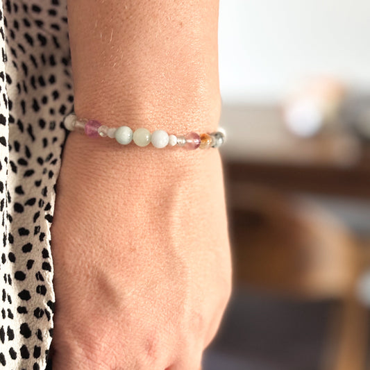 Gemini Crystal Charm Bracelet with a white charm worn on wrist, highlighting its lightweight, flexible fit.