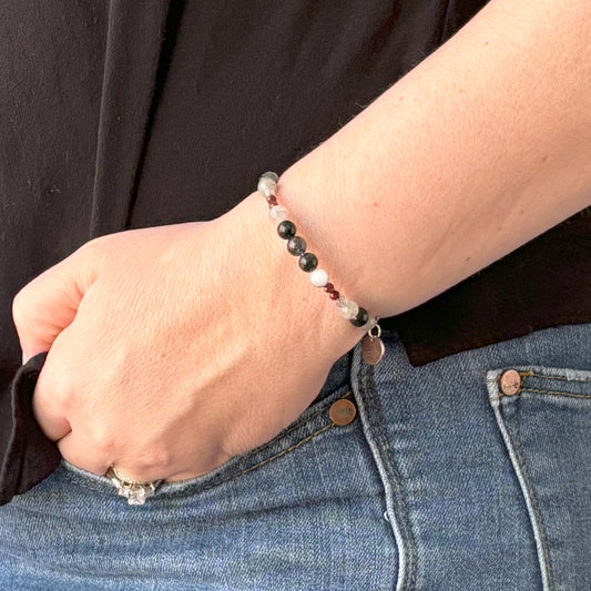 Grounded bangle bracelet worn on wrist featuring earthy and neutral crystal beads