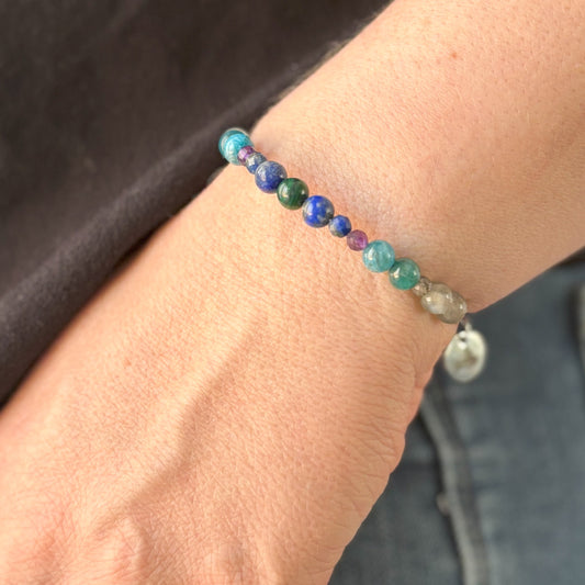 Intuition crystal bangle bracelet worn on wrist with rich blues and purples