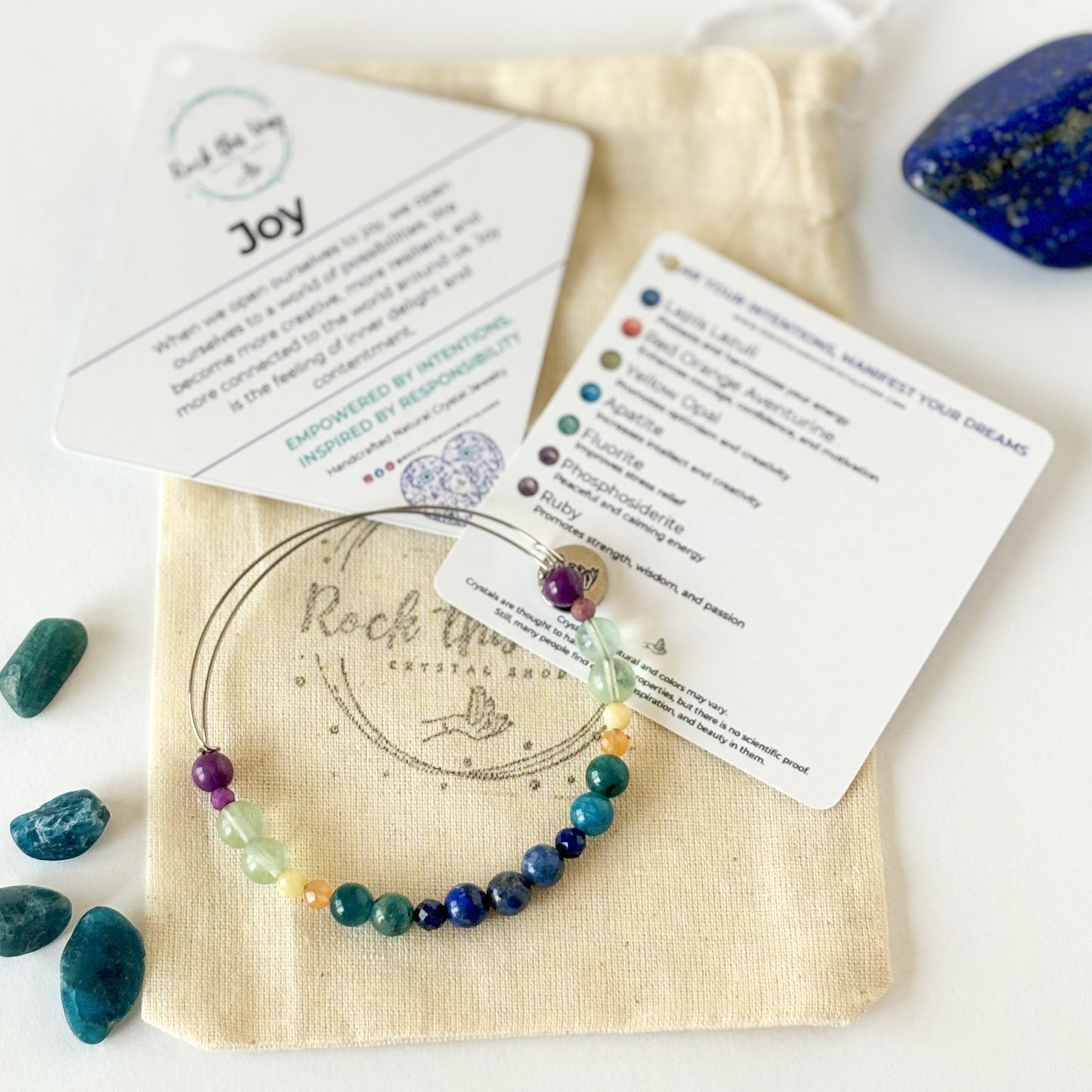 Joy Crystal Bracelet displayed with meaning cards and gift pouch