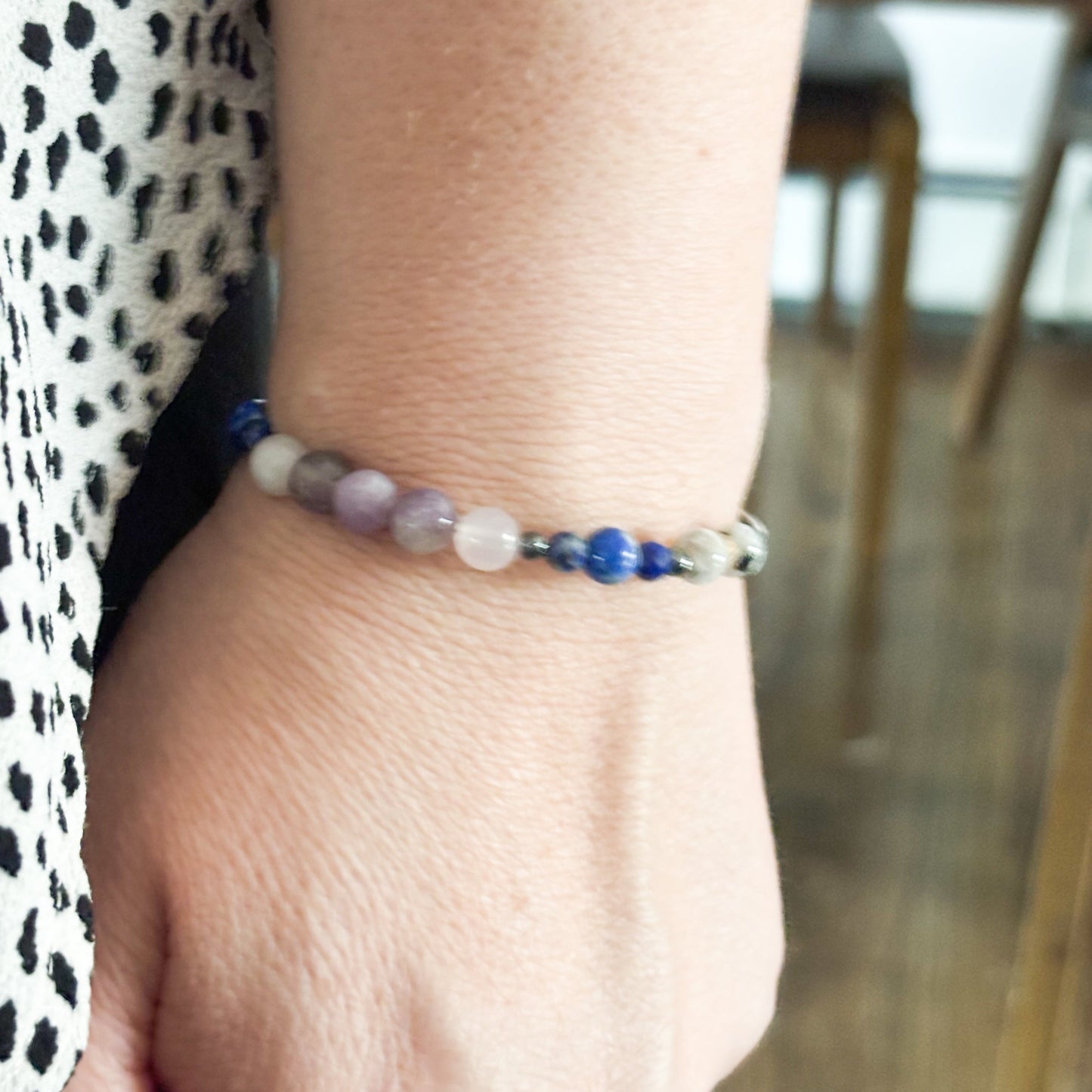 Libra Crystal Charm Bracelet with a white charm worn on wrist, highlighting its lightweight and flexible fit.