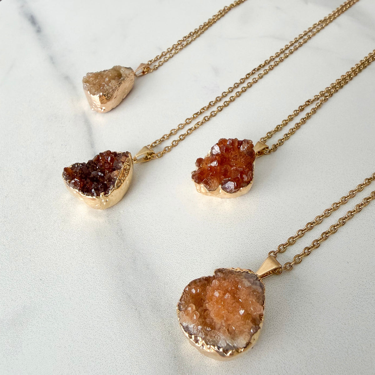 Light to dark citrine drusy cluster pendant with pale golden yellow to deep amber and burnt orange crystal tones in a gold plated setting.
