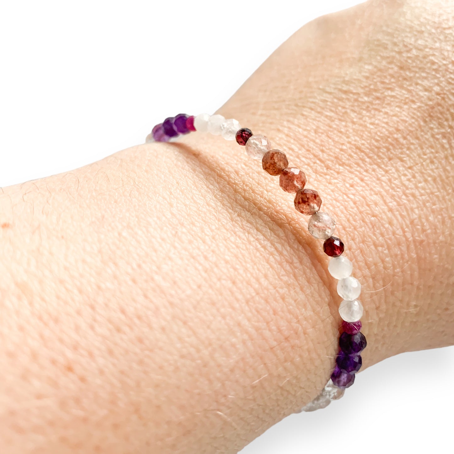 Close-up of the Love Crystal Bracelet with pink and red gemstones worn on wrist