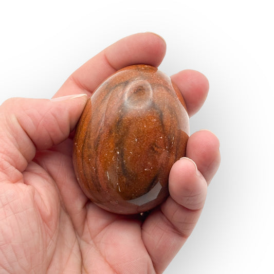 Mahogany Obsidian egg medium size in hand, showing natural brown and black swirls