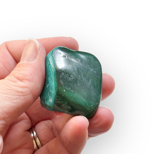 Malacolla Polished Stone held in hand, showing smooth finish and size