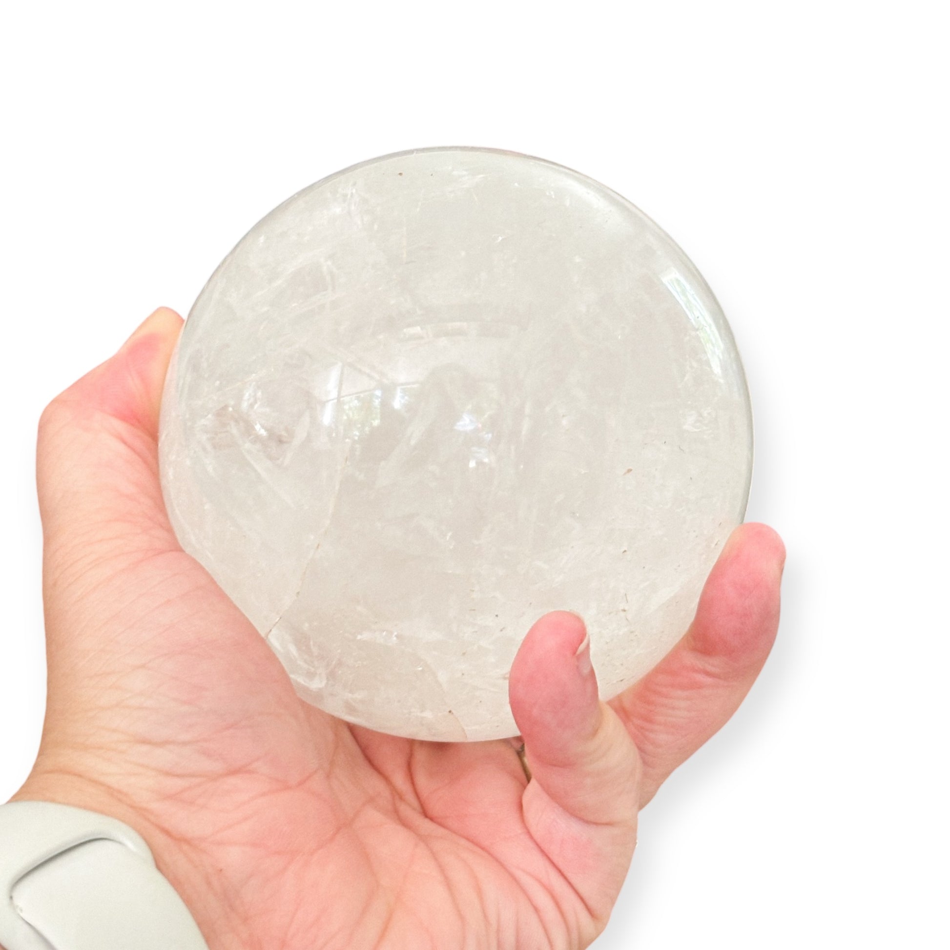 Hand holding a palm-sized Milky Quartz crystal sphere