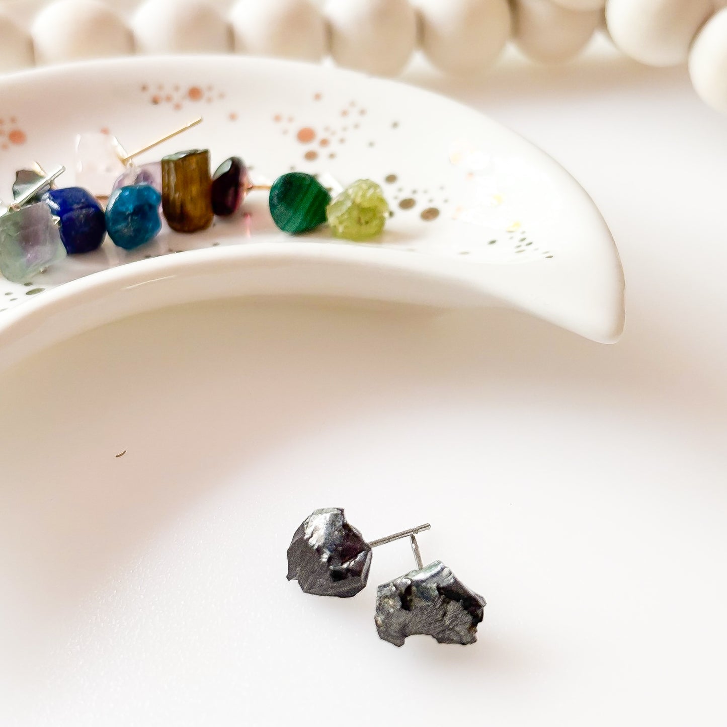 Side view of rough noble shungite stud earrings showing natural shape and texture