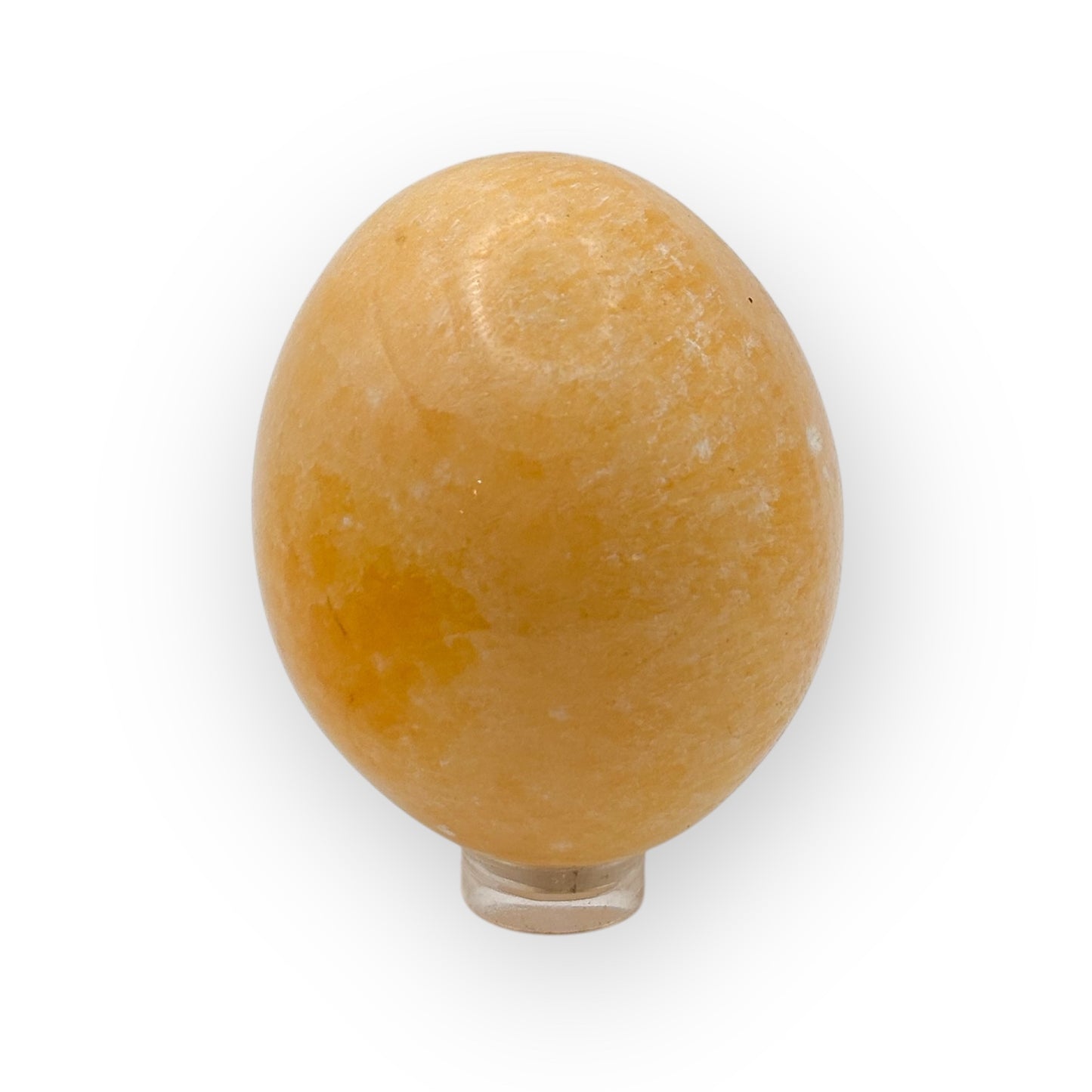 Polished Orange Calcite egg on stand showing warm orange hues and energizing crystal texture