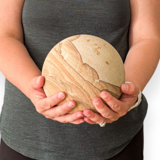 Woman holding a large 12 lb Picture Sandstone Sphere with layered patterns