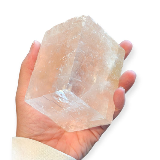 Hand holding Pink Icelandic Spar for size reference