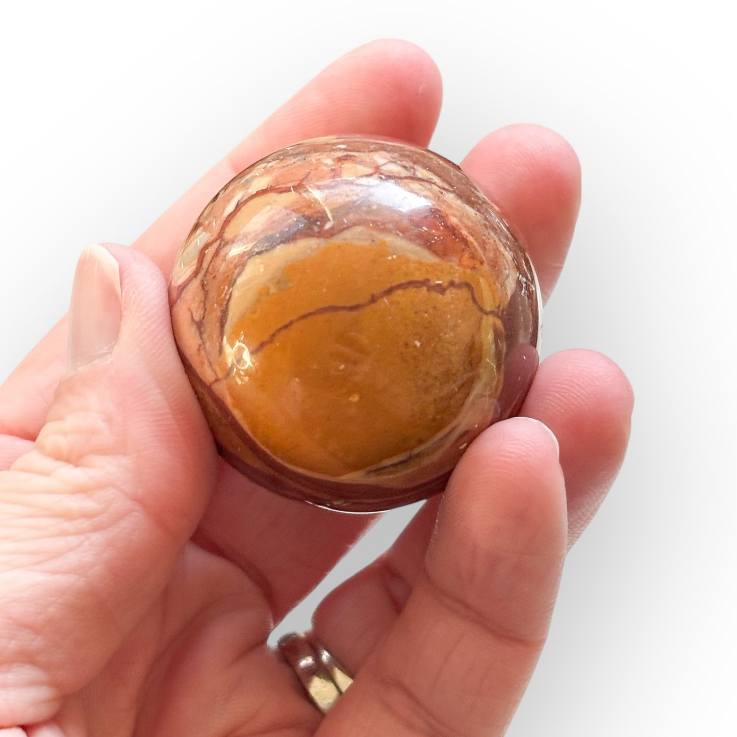 Polychrome Jasper Sphere held in hand for scale and texture