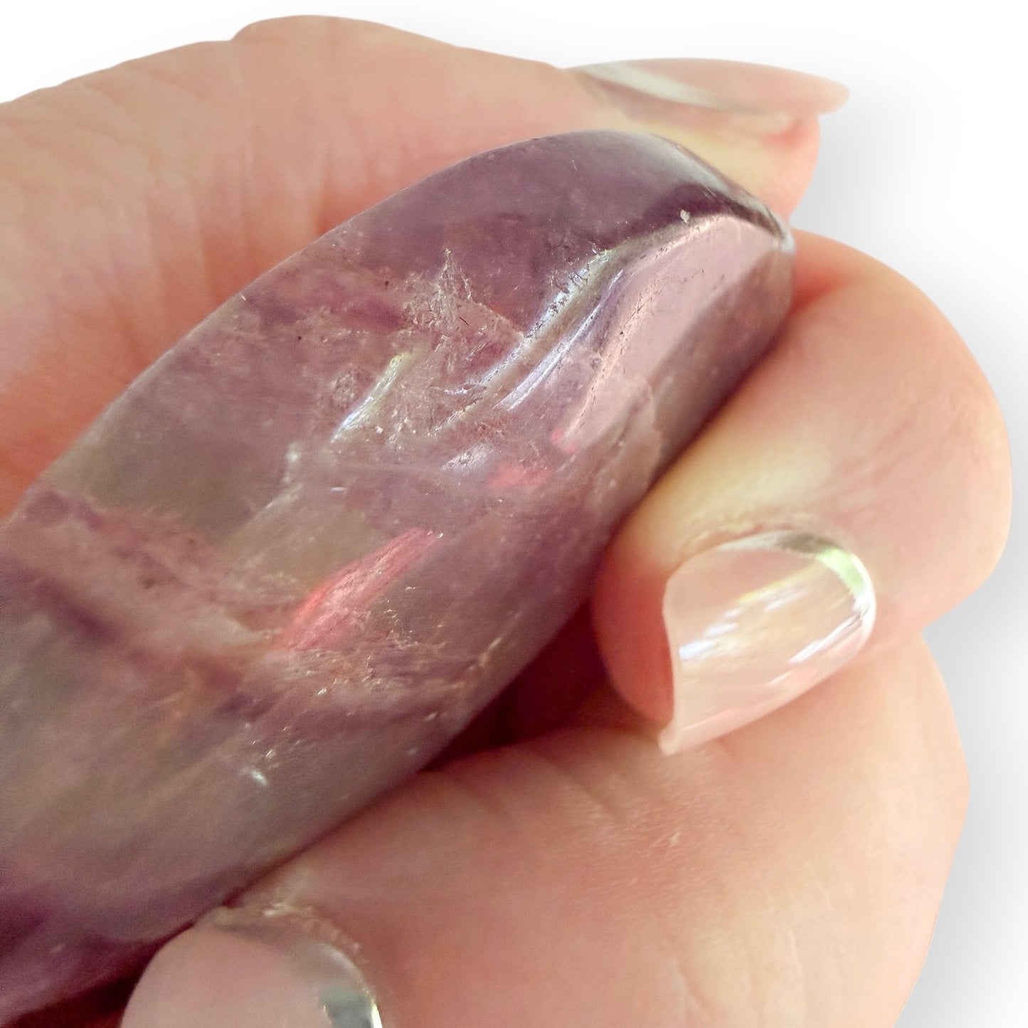 Rainbow fluorite crescent moon crystal carving shown in hand for size reference.