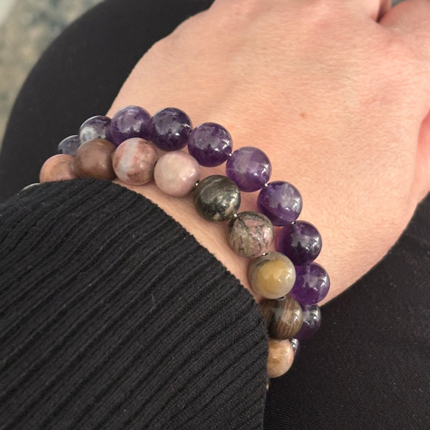 Rhodonite crystal bracelet stacked with other gemstone bracelets for a layered look.