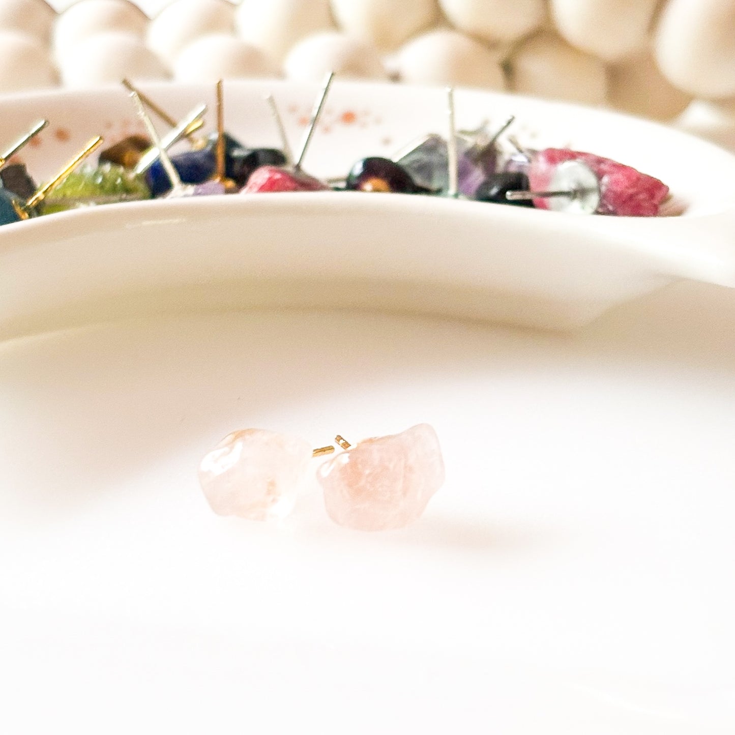 Side view of polished rose quartz stud earrings showing natural shape and texture