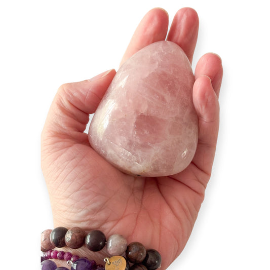Hand holding medium Rose Quartz to show size and polish