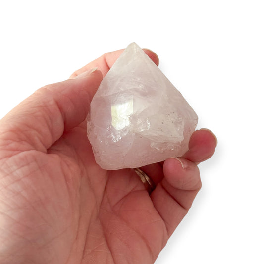 Hand holding Rose Quartz point showing size and natural texture