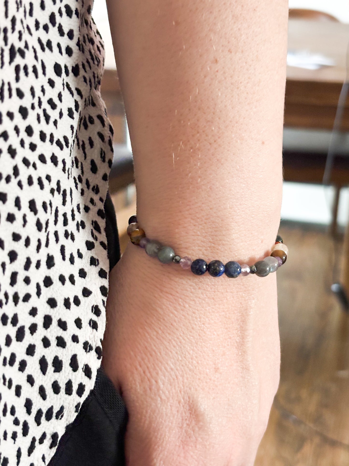 Sagittarius Crystal Charm Bracelet with a white charm worn on wrist, highlighting its flexible, comfortable fit and radiant crystals.